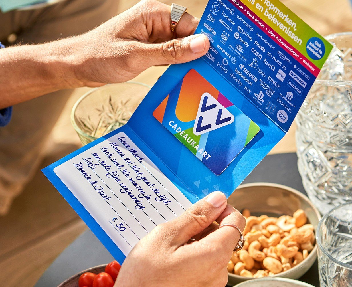 Iemand krijgt een VVV Cadeaukaart met daarbij een handgeschreven boodschap.